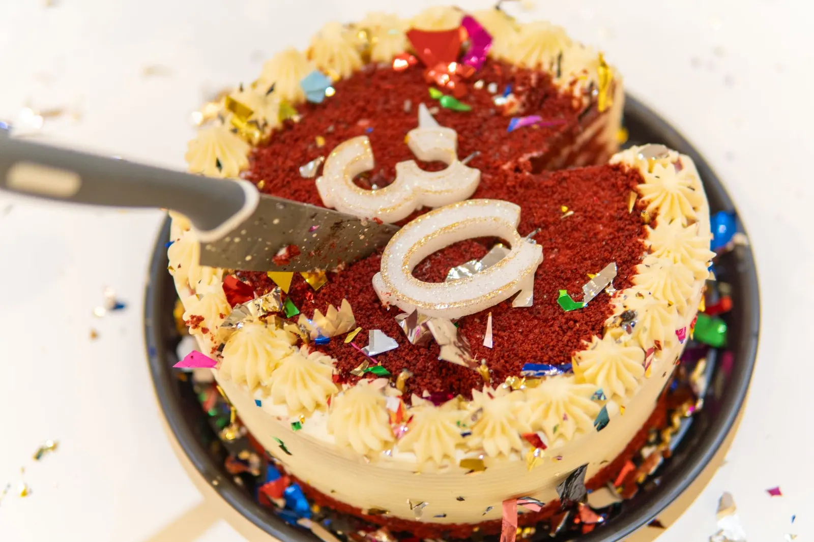 Vibrant red velvet cake with cream frosting and colorful candles, perfect for a birthday celebration. Celebrity birthdays in December 2027: a dated guide for holiday planning