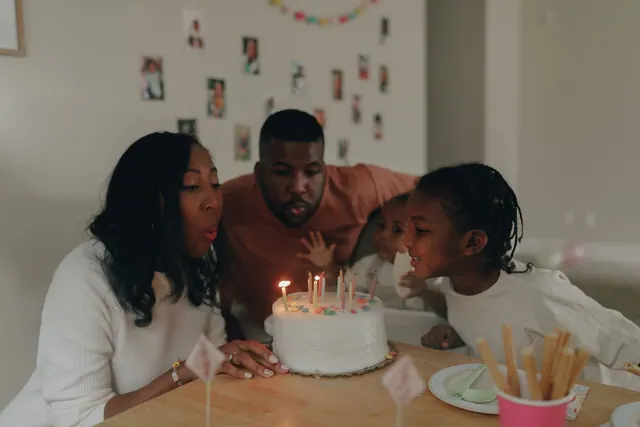 A joyful family moment as parents and children blow out birthday candles on a cake indoors. Historical figures with January birthdays: the practical version