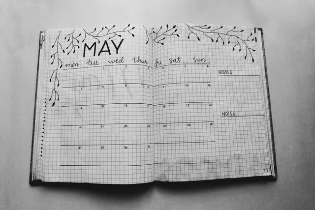 Open notebook displaying a minimalist May planner with handwritten days and decorative elements. Which parts of May birthdays deserve the closest look?