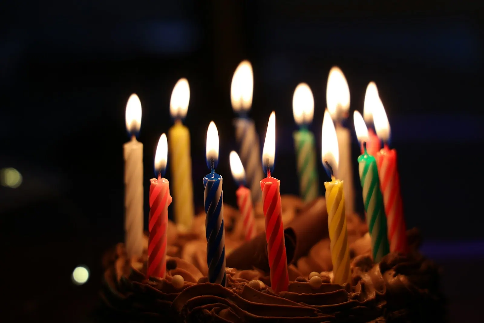 lighted candles on brown cake birthday  candles. May birthdays facts about dates, signs and patterns