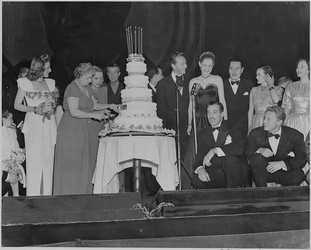 Photograph of First Lady Bess Truman cutting the cake at the Roosevelt Birthday Ball, as Paul Henreid, Alexis Smith, Cesar Romero, Van Johnson, and other Hollywood celebrities look on. Why do the usual assumptions about young celebrities with July birthdays keep failing?